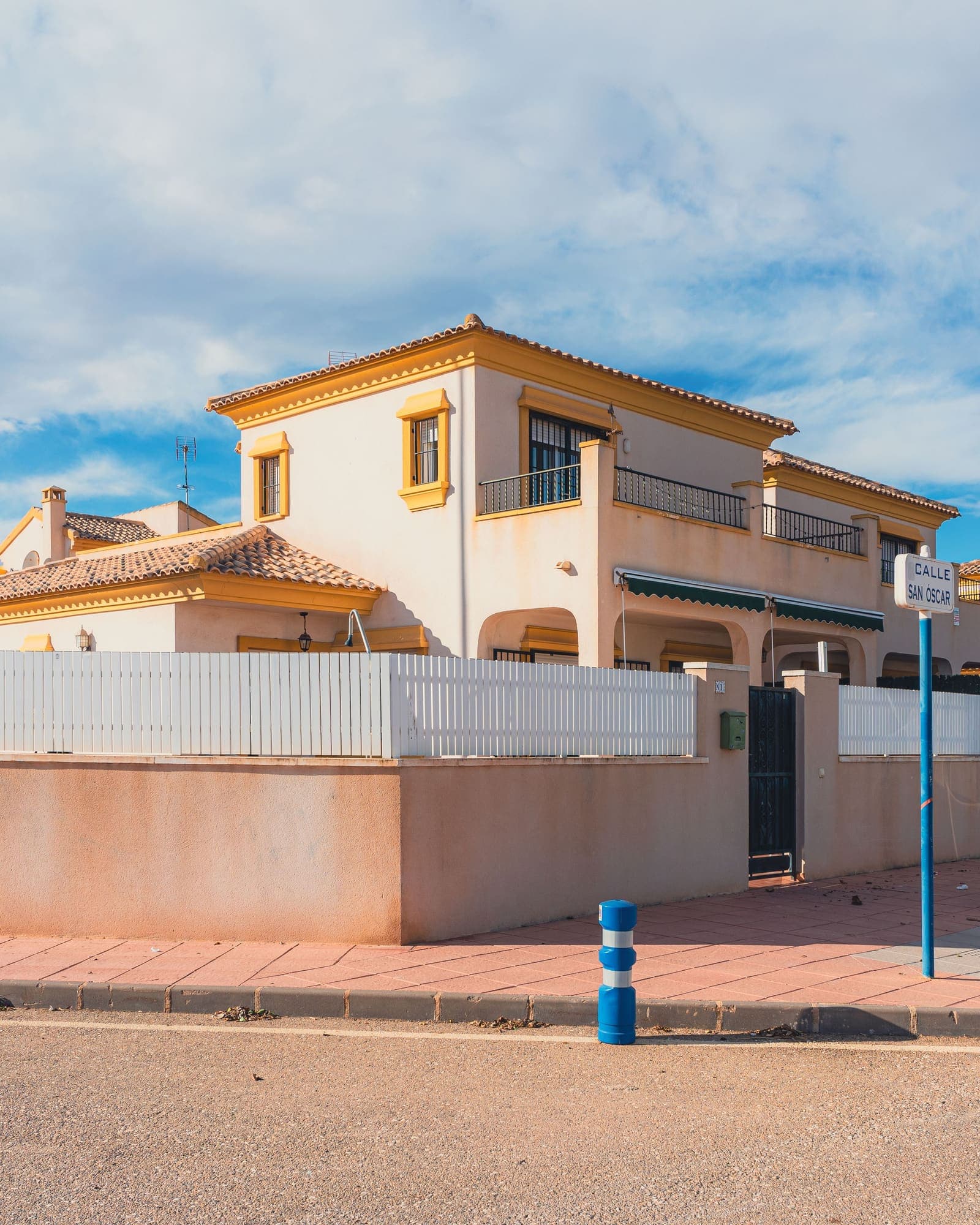 Casa unifamiliar de dues plantes amb teulada de teula i tanca, en una cantonada